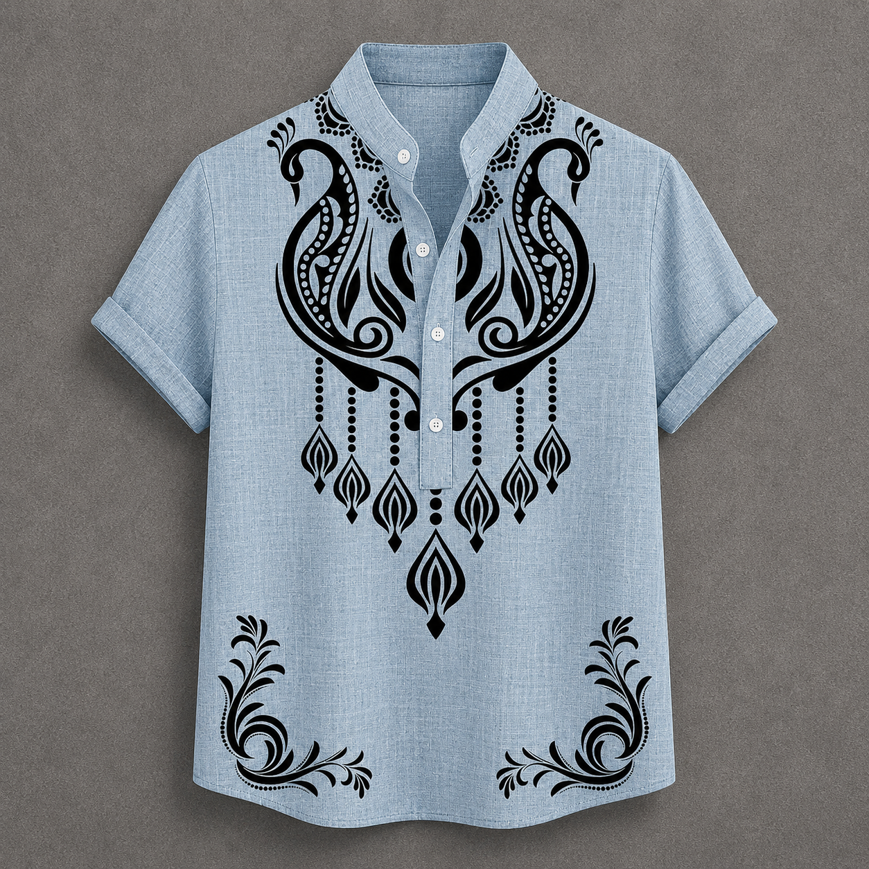 A light blue short-sleeve button-up shirt with black ornate paisley and floral embroidery on the front, displayed flat against a textured gray background.