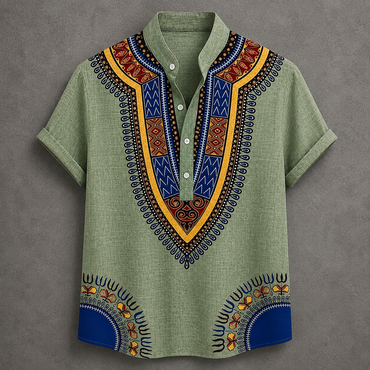 A men's short-sleeve button-up shirt in sage green with a vibrant African dashiki print. The shirt features a V-neck collar with geometric patterns in blue, yellow, orange, and black, and matching patterns are printed on the lower front hem.