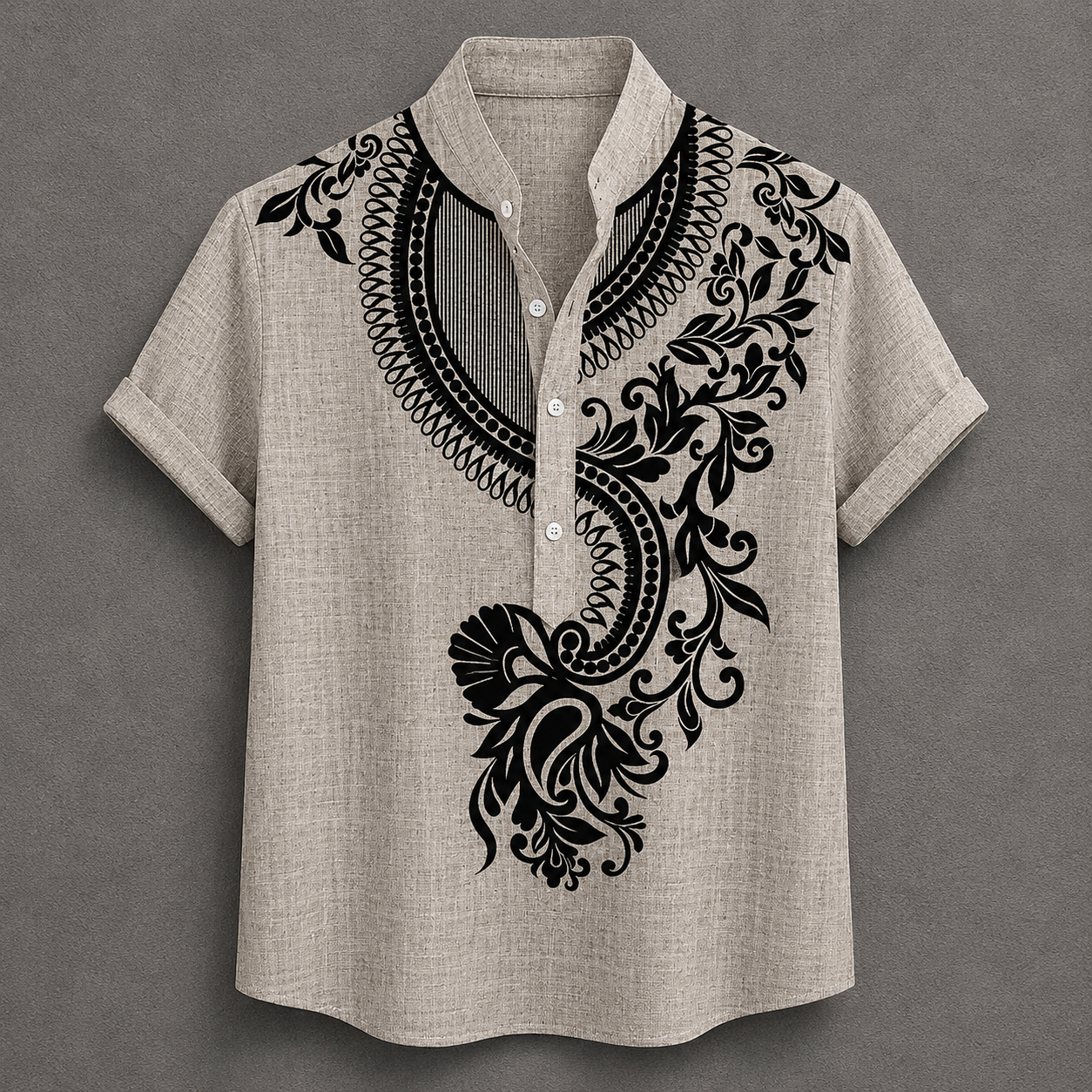 A men's short-sleeve button-up shirt in a light beige linen-like fabric, featuring a black ornate floral and scroll pattern printed on the chest and shoulders, set against a dark gray background.