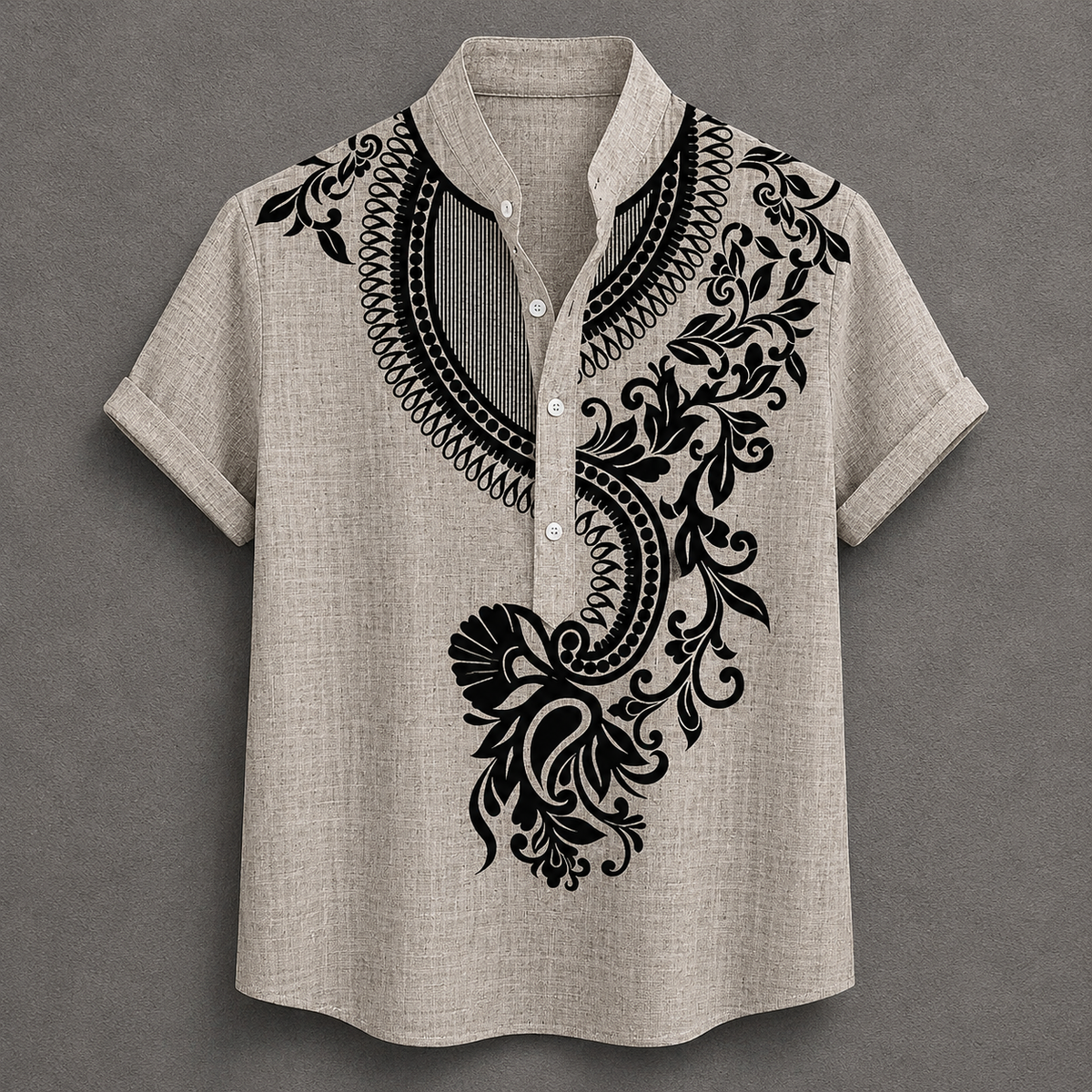 A men's short-sleeve button-up shirt in a light beige linen-like fabric, featuring a black ornate floral and scroll pattern printed on the chest and shoulders, set against a dark gray background.