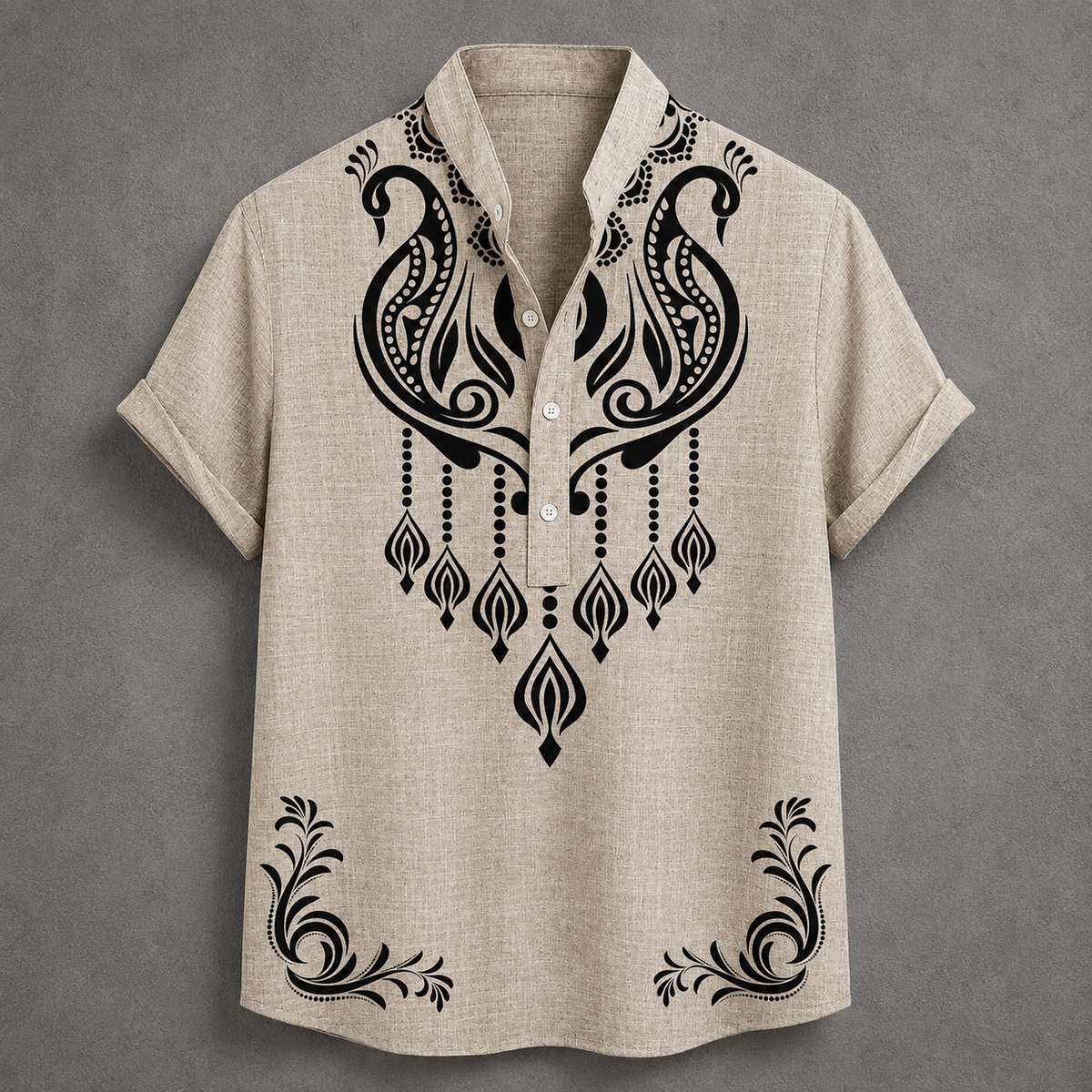 A beige short-sleeve button-up shirt with black ornate tribal-style embroidery on the chest and lower hem, displayed flat against a textured gray background.