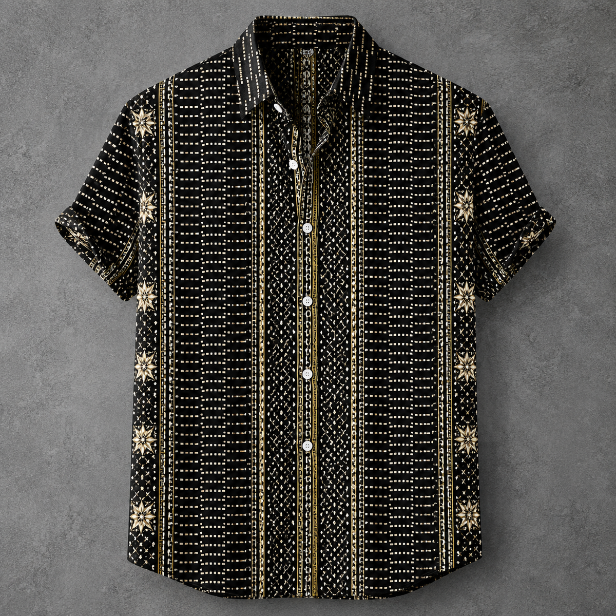 A short-sleeve button-up shirt with a black base and vertical stripes of white dots and gold accents, featuring small gold snowflake motifs on the sides, laid flat on a textured gray background.