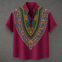 A short-sleeve button-up shirt in deep magenta, featuring a large, vibrant, multicolored African dashiki-style print on the V-neck panel, collar, and sleeve cuffs, set against a dark gray background.