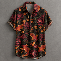 A short-sleeve button-up shirt with a black background and an all-over print of red and orange koi fish, peony flowers, and orange marigold flowers, displayed flat against a textured gray background.