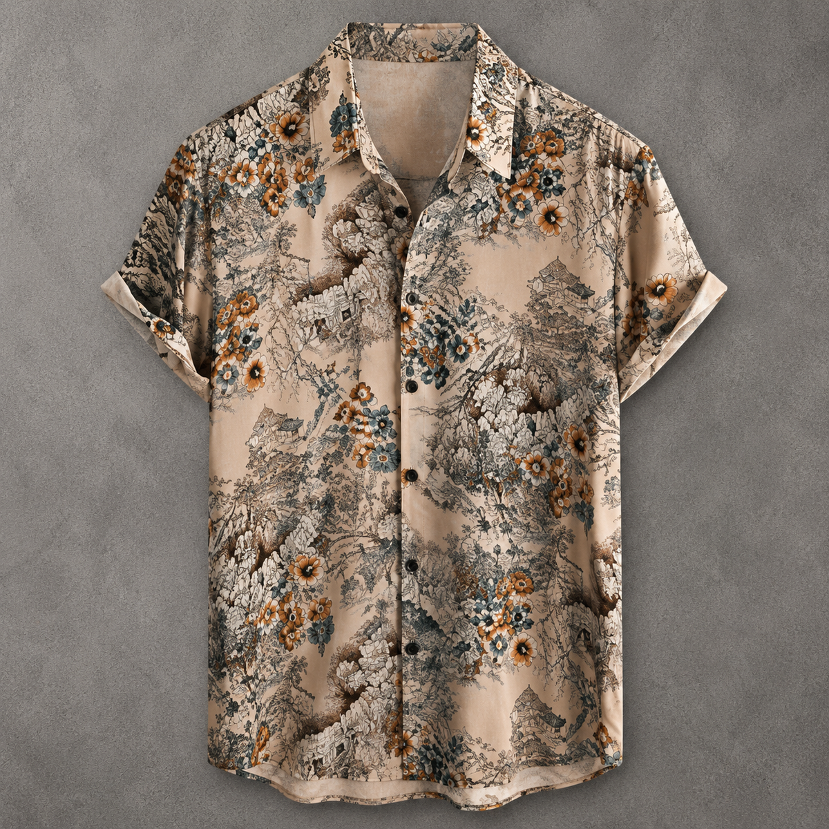 A short-sleeve button-up shirt with a beige base and an intricate, painterly floral and landscape pattern in brown, gray, and muted blue, laid flat against a textured gray background.