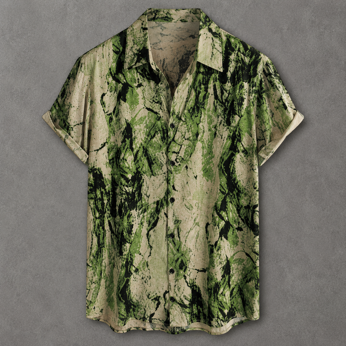 A short-sleeve button-up shirt with a green and beige abstract leaf-like print, displayed flat against a textured gray background.