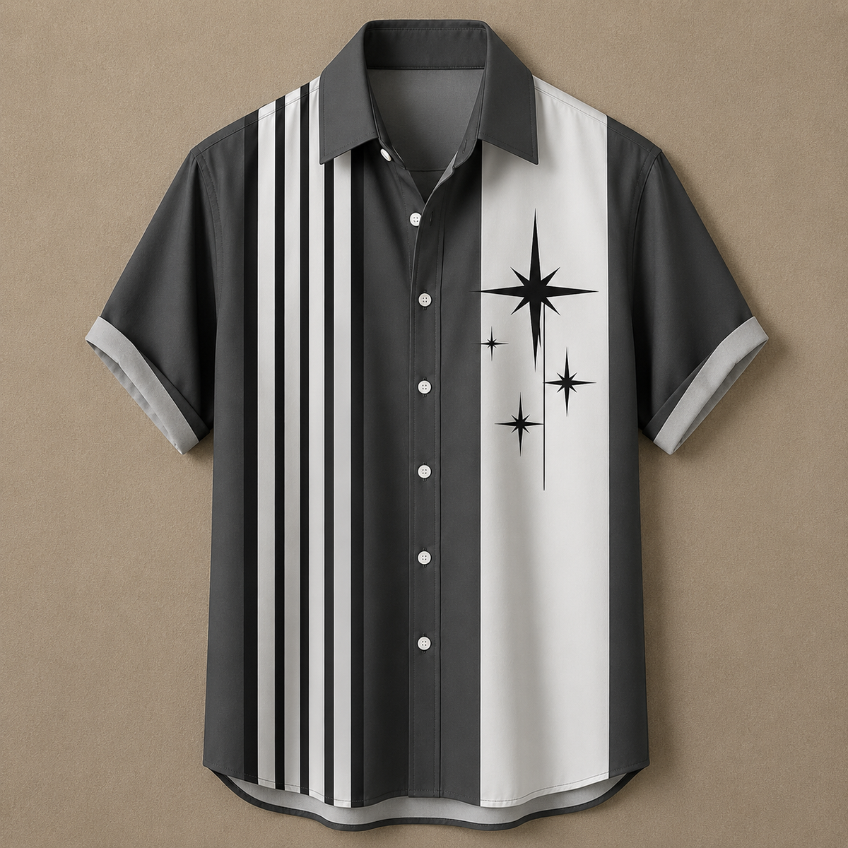 A short-sleeve button-up shirt with a dark gray and white vertical split design, featuring black stripes on the left side and black starburst graphics on the right side, displayed against a solid tan background.