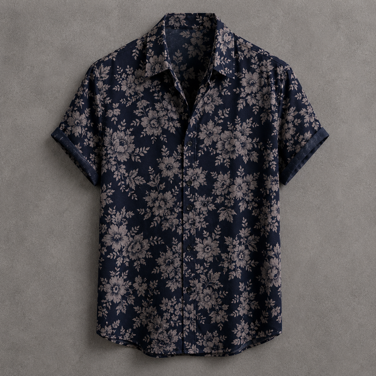 A short-sleeve button-up shirt with a dark navy blue base and an all-over light beige floral pattern, displayed flat against a textured gray background.