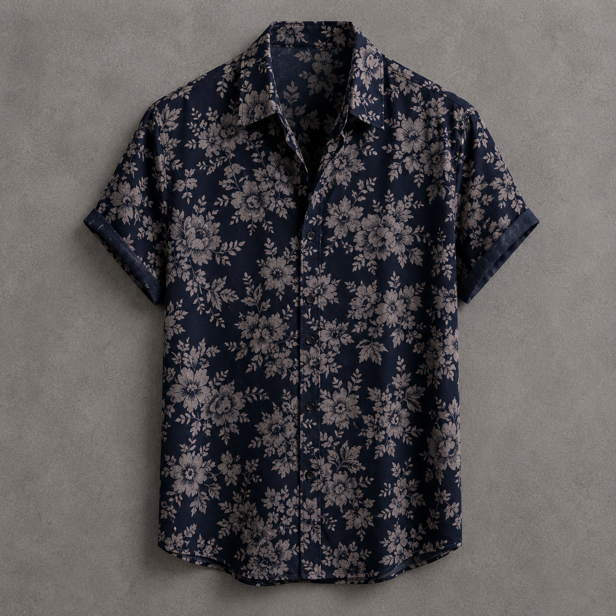 A short-sleeve button-up shirt with a dark navy blue base and an all-over light beige floral pattern, displayed flat against a textured gray background.