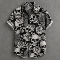 A short-sleeve button-up shirt with a black and white graphic print featuring skulls, roses, and birds, laid flat on a textured gray background.