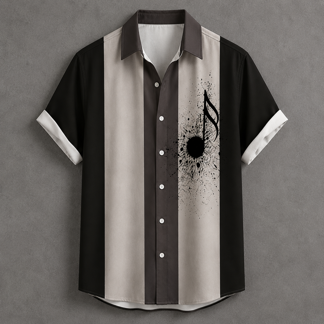 A short-sleeve button-up shirt with vertical stripes in black, dark brown, and light beige, featuring a black music note and ink splatter graphic on the right side, displayed against a textured gray background.