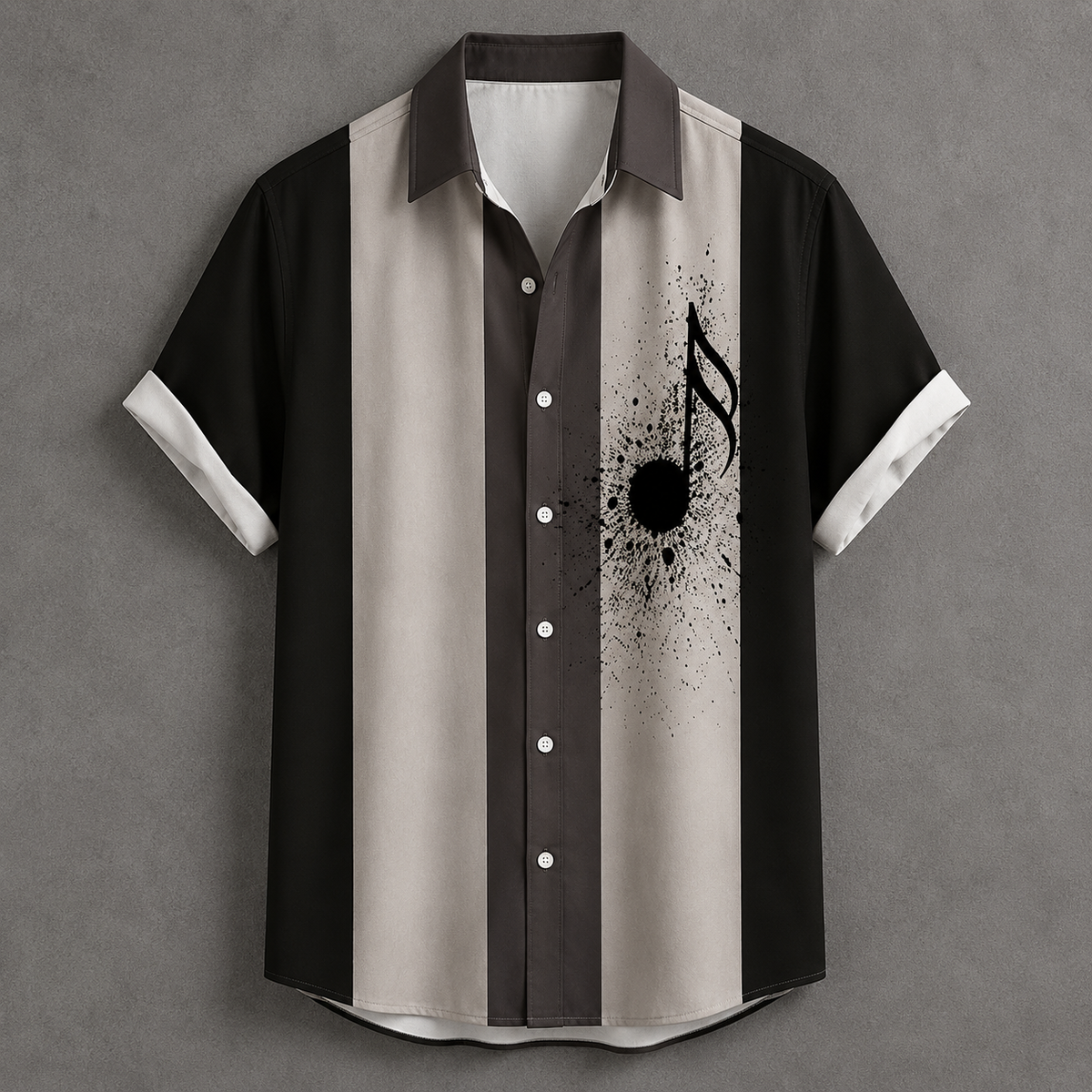A short-sleeve button-up shirt with vertical stripes in black, dark brown, and light beige, featuring a black music note and ink splatter graphic on the right side, displayed against a textured gray background.