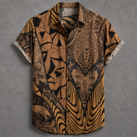 A short-sleeve button-up shirt with a complex, high-contrast graphic print featuring stylized faces, tribal patterns, and geometric shapes in black, brown, and tan, displayed flat against a textured gray background.