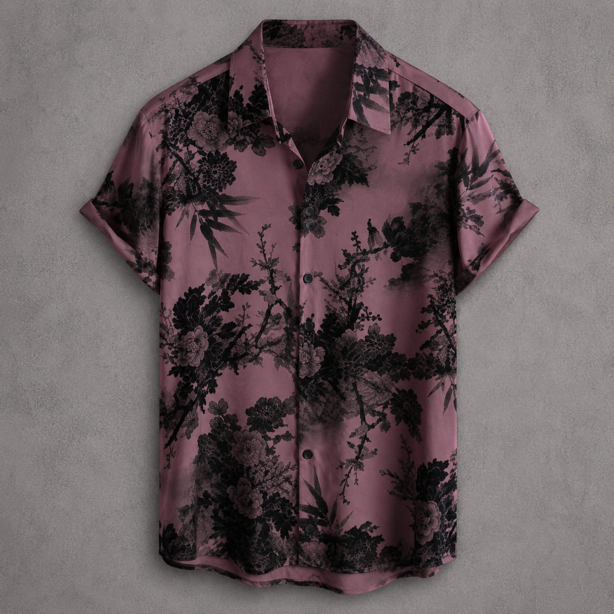 A short-sleeve button-up shirt in dusty mauve with a black floral and botanical print, displayed flat against a textured gray background.