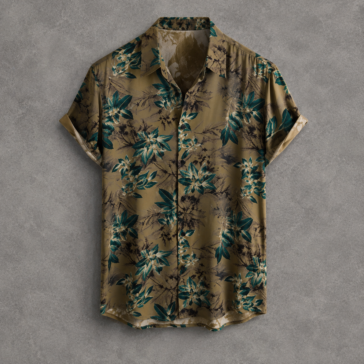 A short-sleeve button-up shirt with a tropical floral print in olive green, teal, and beige, laid flat against a textured gray background.