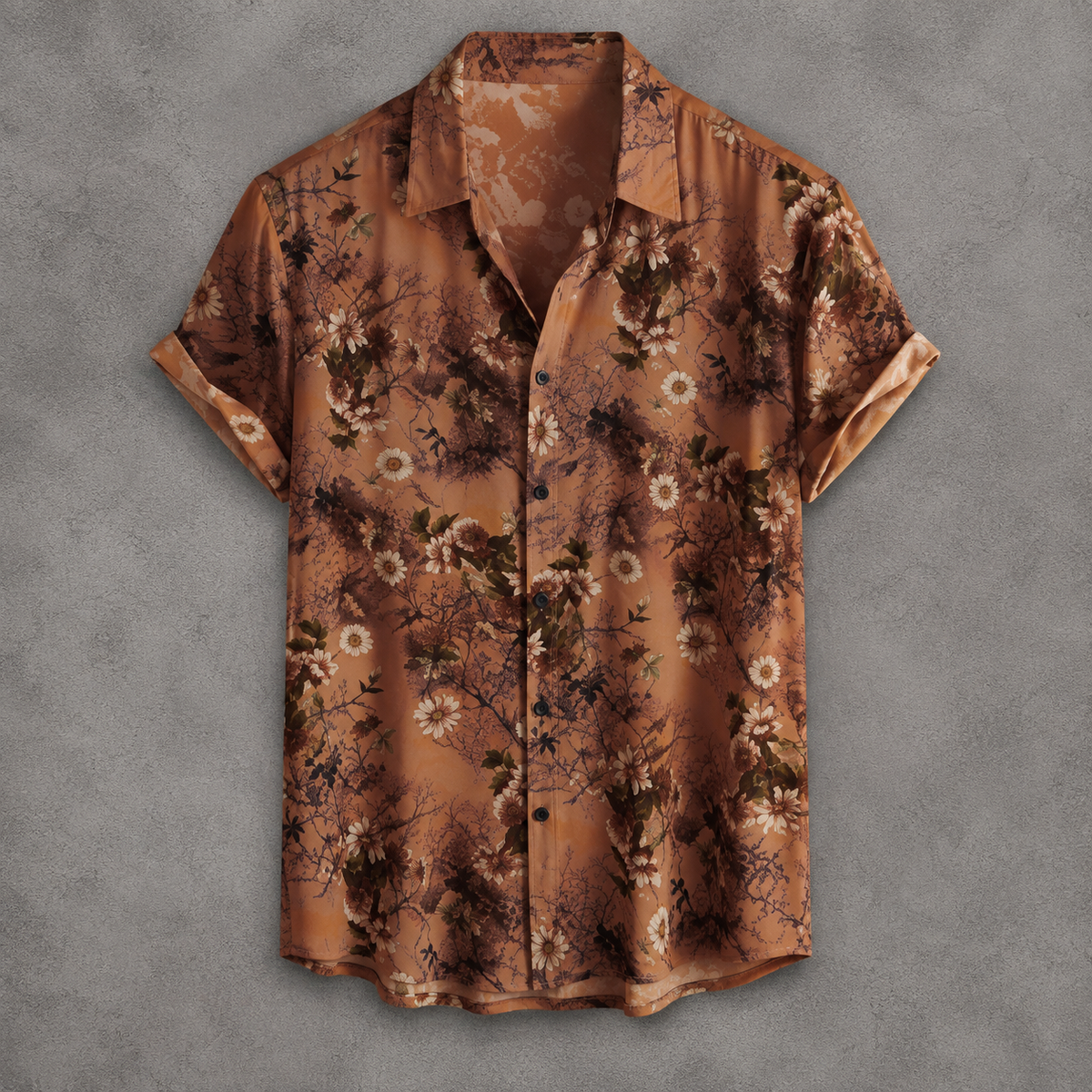 A short-sleeve button-up shirt with a brown and tan floral print, laid flat against a textured gray background.