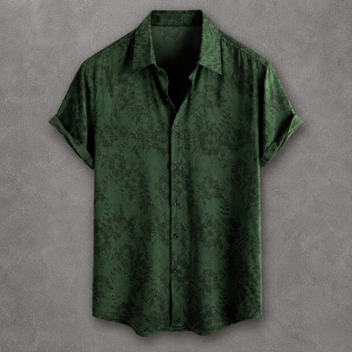 A dark green short-sleeve button-up shirt with a subtle tonal damask pattern, displayed flat against a textured gray background.