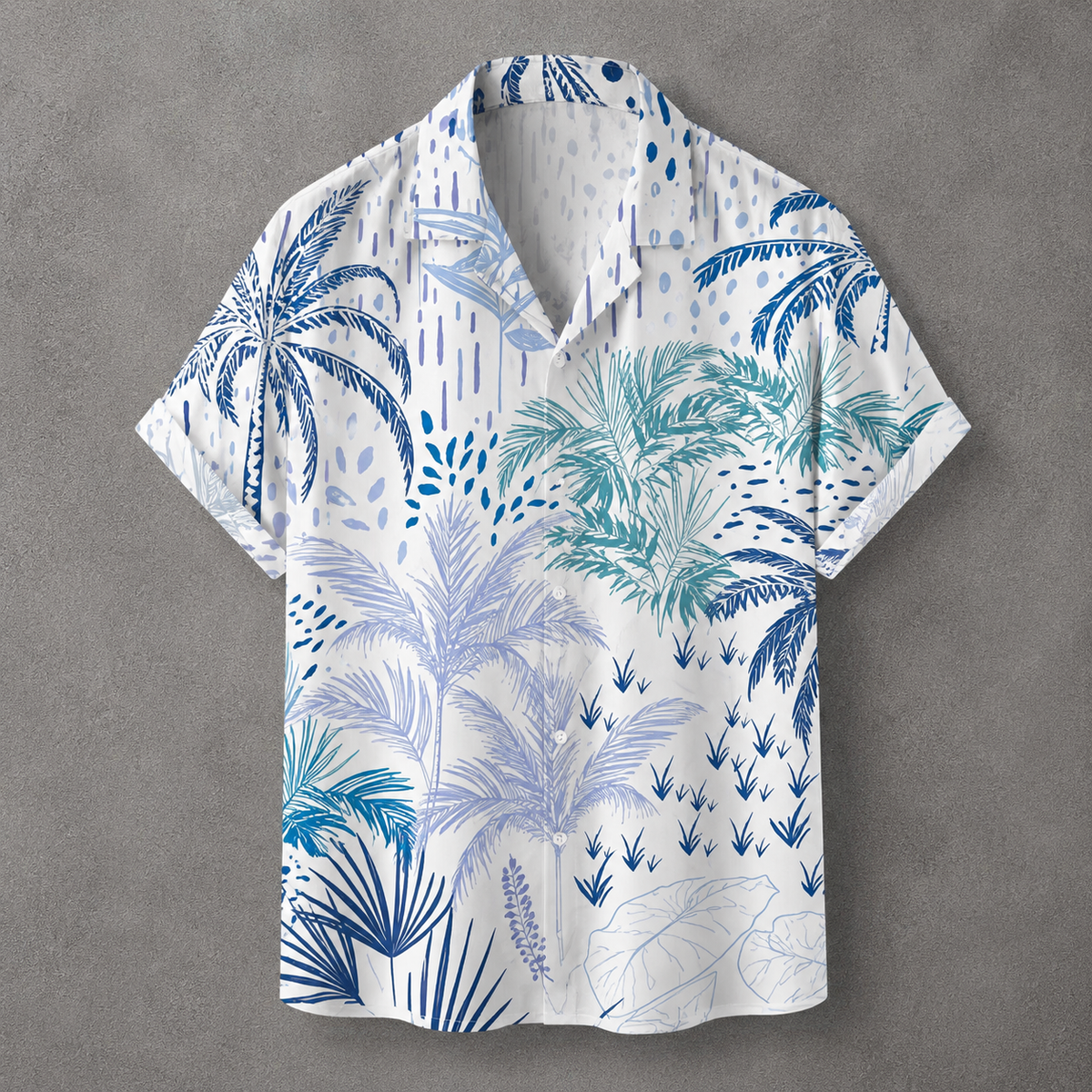 A short-sleeve button-up camp shirt with a white base and a tropical palm tree print in shades of blue and teal, laid flat on a textured gray background.