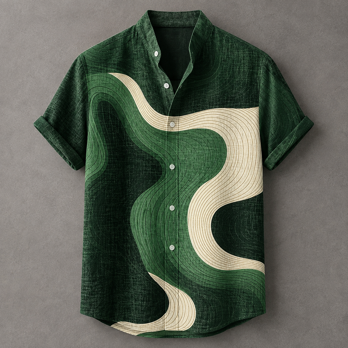 A short-sleeve button-up shirt in textured dark green with an abstract wavy pattern in cream and lighter green, laid flat on a gray background.