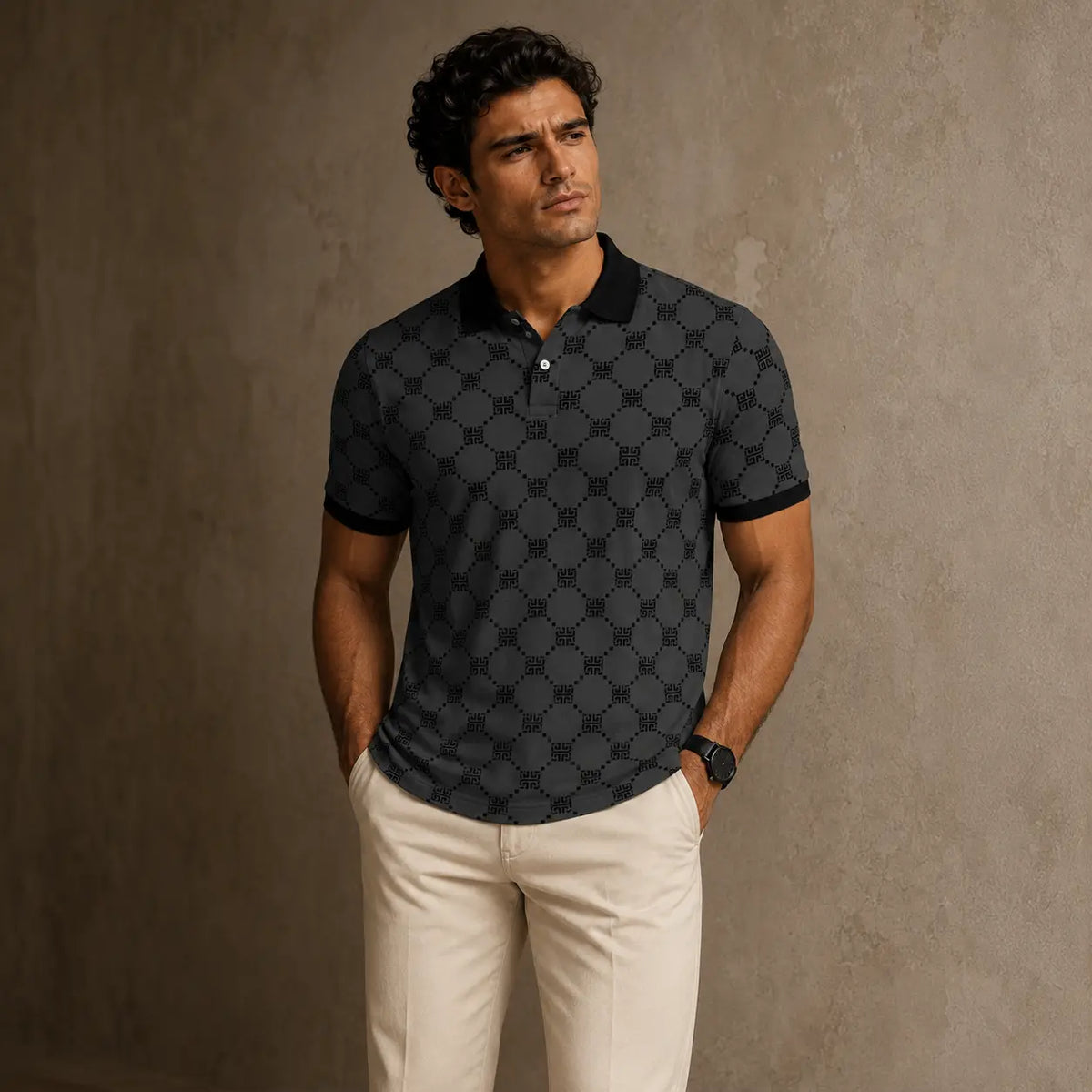 Man wearing a black patterned polo shirt and beige pants against a brown background