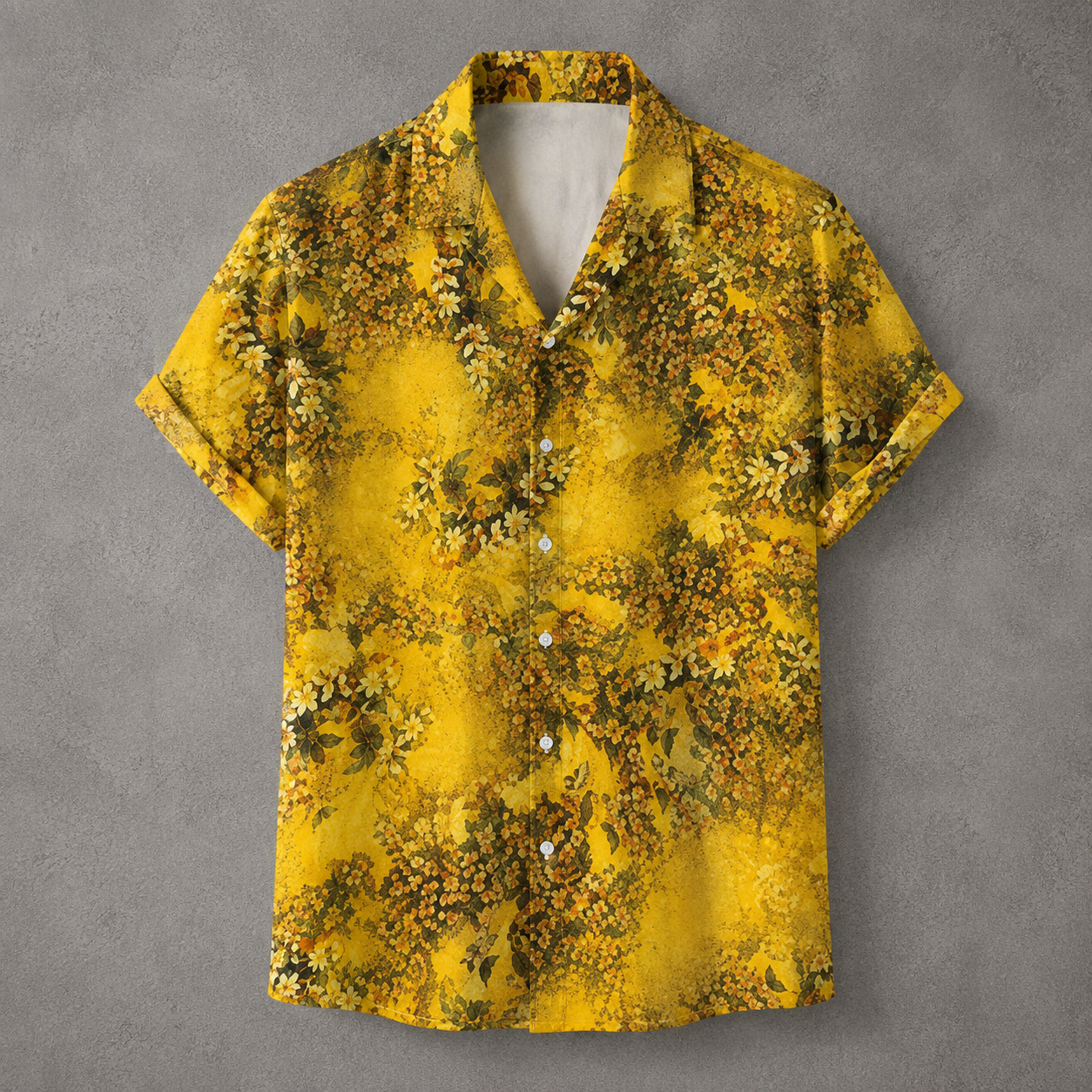 A short-sleeve button-up camp shirt with a vibrant yellow and olive green floral pattern, displayed flat against a textured gray background.