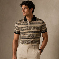 Man wearing a patterned polo shirt and beige pants against a neutral background