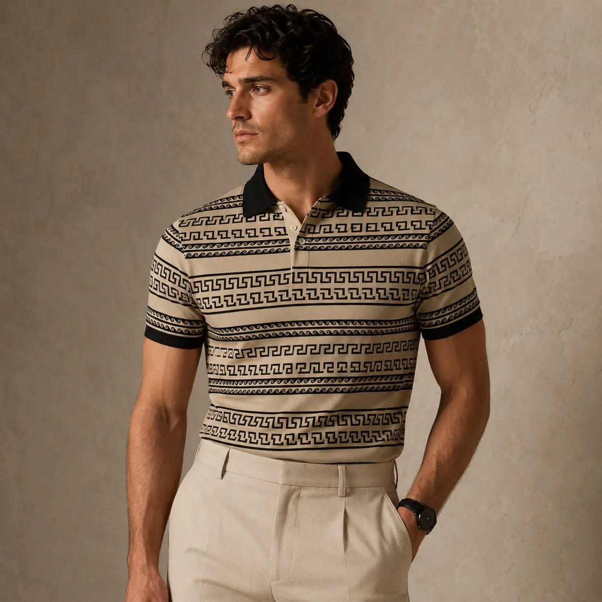 Man wearing a patterned polo shirt and beige pants against a neutral background
