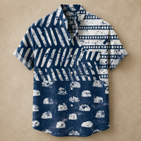 A short-sleeve button-up shirt with a distressed ikat-style pattern in navy blue and white, laid flat on a textured beige background.
