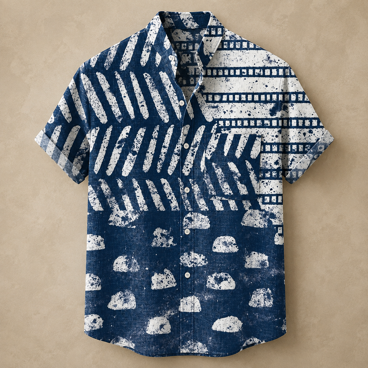 A short-sleeve button-up shirt with a distressed ikat-style pattern in navy blue and white, laid flat on a textured beige background.
