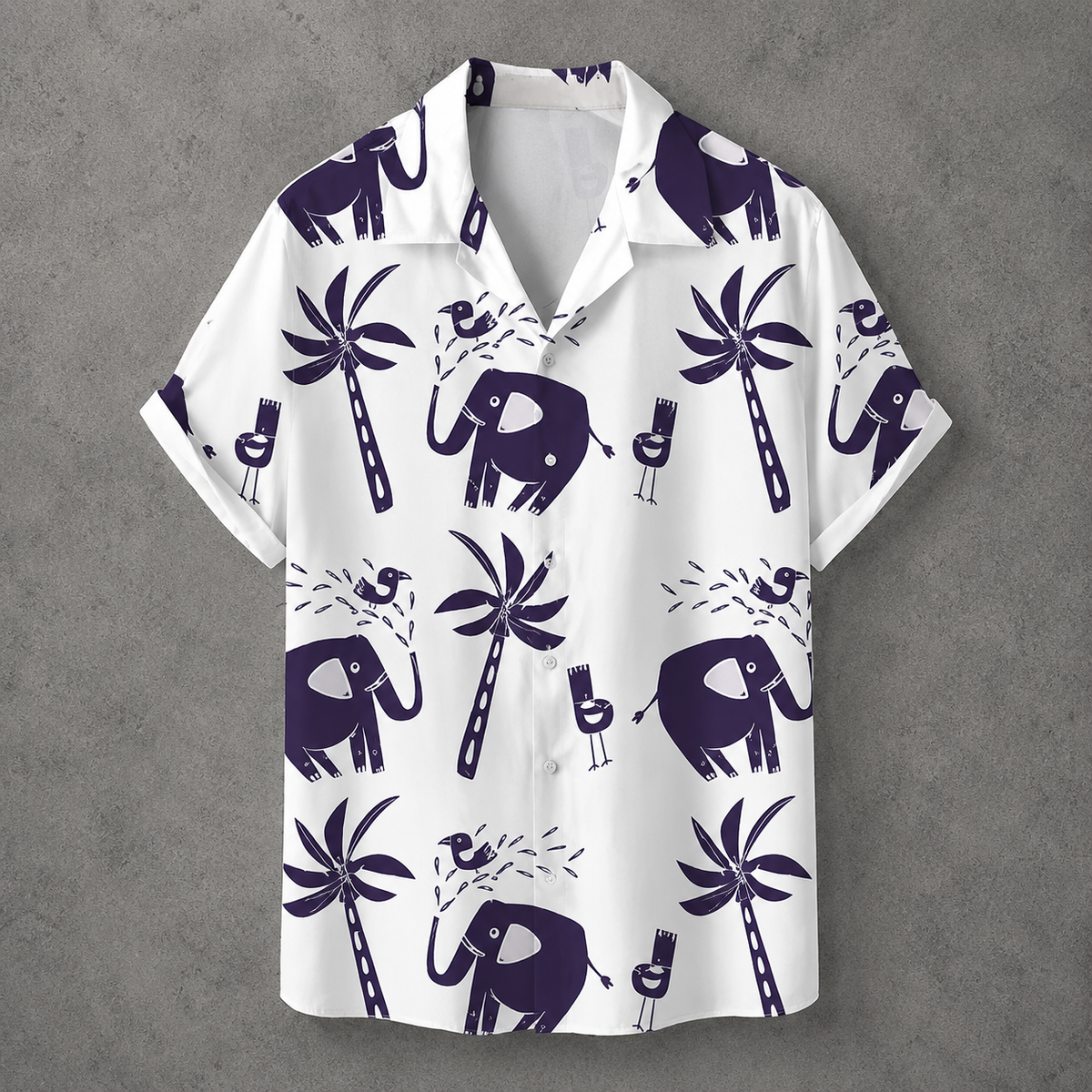A white short-sleeve camp collar button-up shirt with a dark purple tropical print featuring elephants, palm trees, and cocktail glasses, displayed flat against a textured gray background.