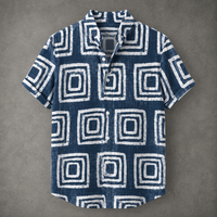 A short-sleeve button-up shirt with a blue and white geometric pattern, laid flat on a textured gray background.