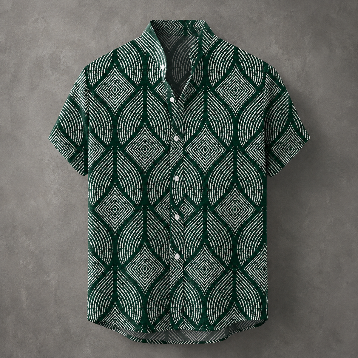 A short-sleeve button-up shirt with a dark green and white geometric leaf pattern, displayed against a textured gray background.