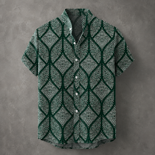 A short-sleeve button-up shirt with a dark green and white geometric leaf pattern, displayed against a textured gray background.