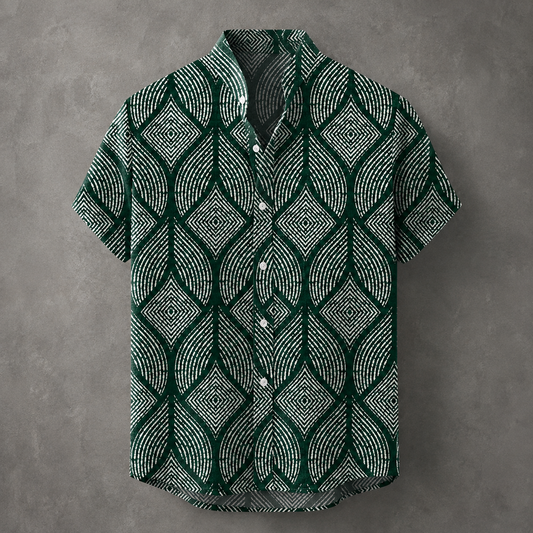 A short-sleeve button-up shirt with a dark green and white geometric leaf pattern, displayed against a textured gray background.