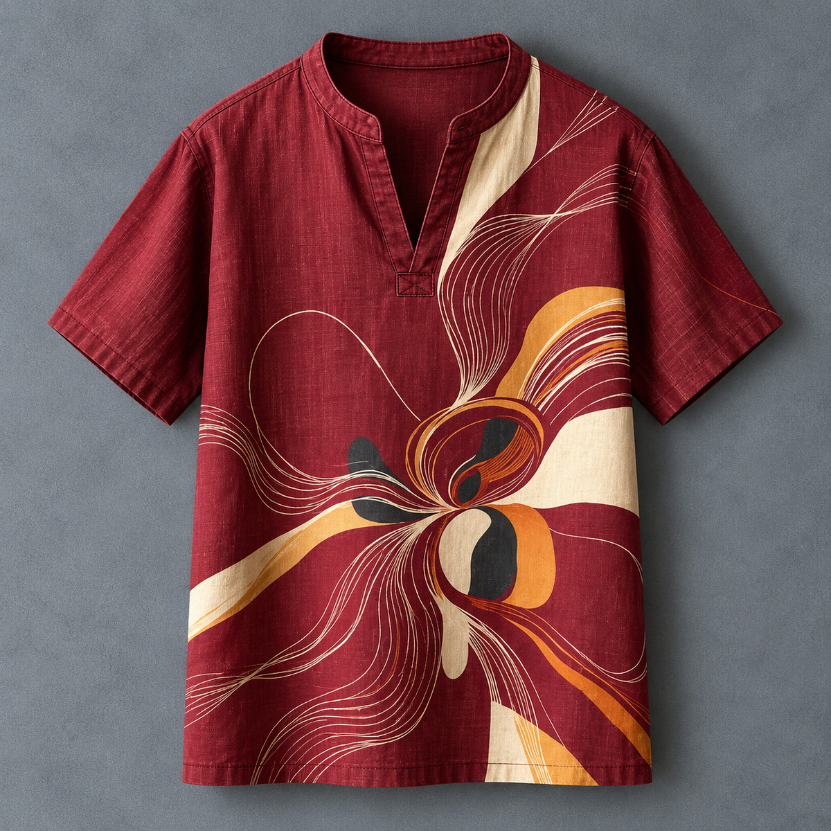 A short-sleeve men's shirt in deep burgundy with an abstract floral pattern in cream, orange, and black, laid flat against a textured gray background.