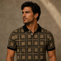 Man wearing a patterned polo shirt against a textured wall.