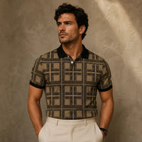 Man wearing a patterned shirt and white pants against a textured beige wall