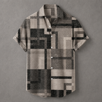 A short-sleeve button-up shirt with a geometric block pattern in beige, gray, and black, displayed flat against a textured gray background.
