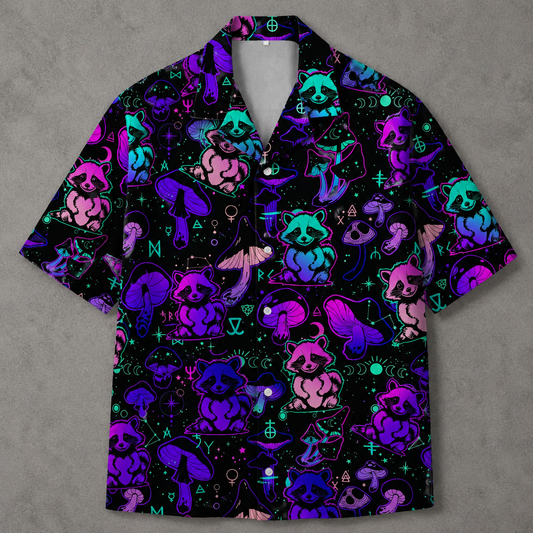 A short-sleeve button-up camp shirt with a black background and a vibrant neon pattern of raccoons, mushrooms, and occult symbols in purple, pink, and blue.