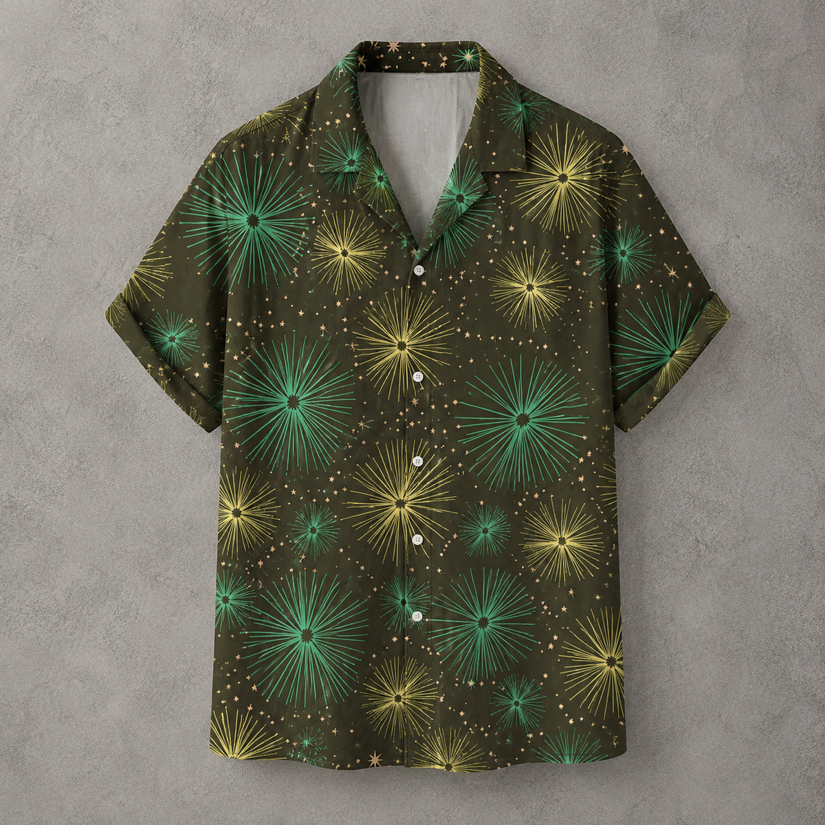 A short-sleeve button-up camp shirt with a dark olive green base, featuring a vibrant pattern of green and yellow starburst dandelions and small gold dots, displayed against a textured gray background.