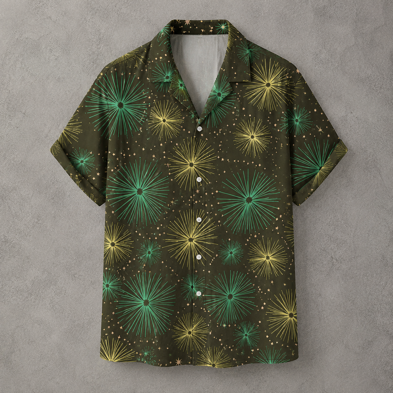 A short-sleeve button-up camp shirt with a dark olive green base, featuring a vibrant pattern of green and yellow starburst dandelions and small gold dots, displayed against a textured gray background.
