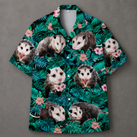 A short-sleeve button-up camp shirt featuring a tropical print of green palm leaves and pink flowers, overlaid with repeated images of opossums, displayed flat against a gray background.