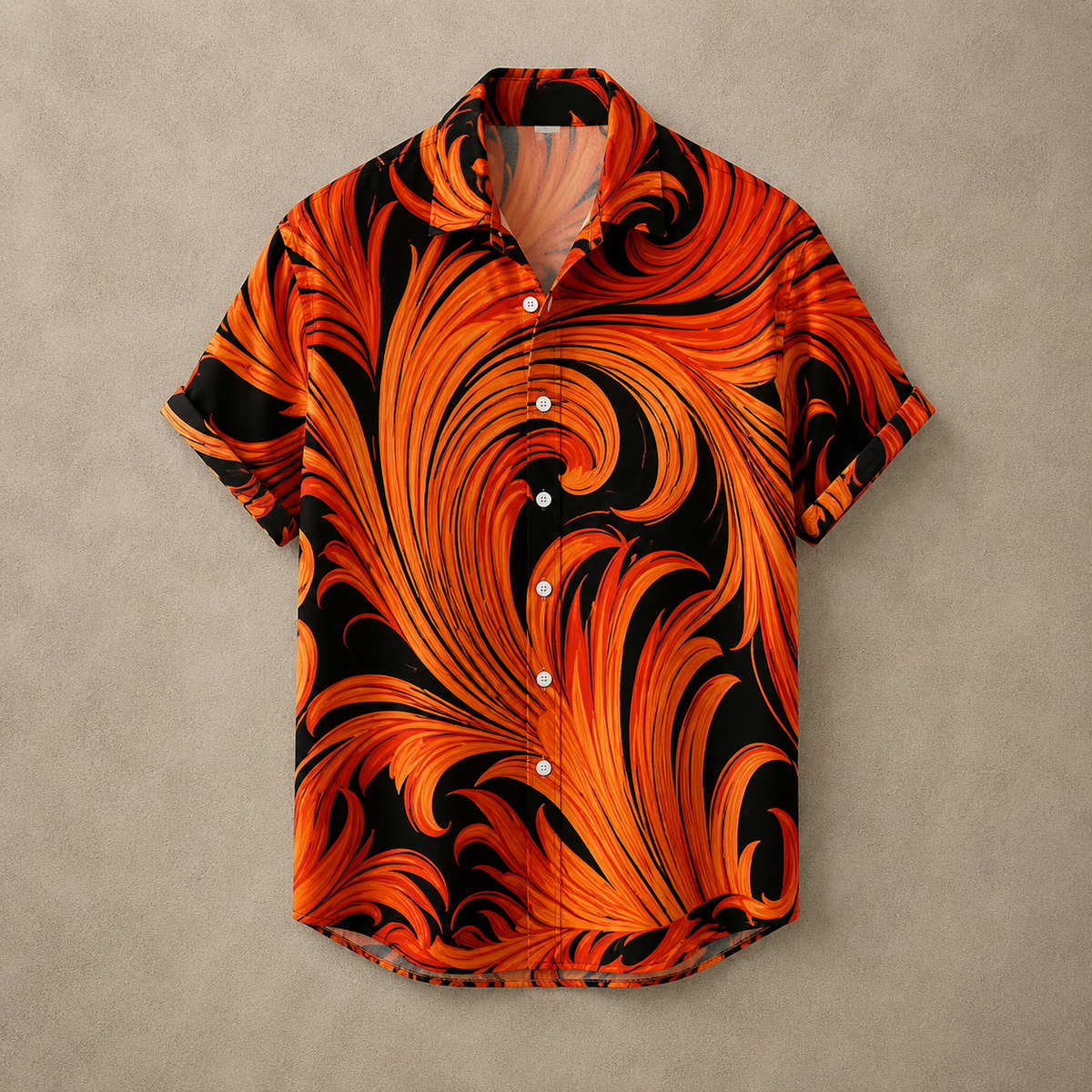A short-sleeve button-up shirt with a bold orange and black swirling abstract print, laid flat on a textured gray background.