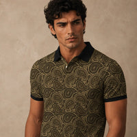 Man wearing a patterned polo shirt against a beige background