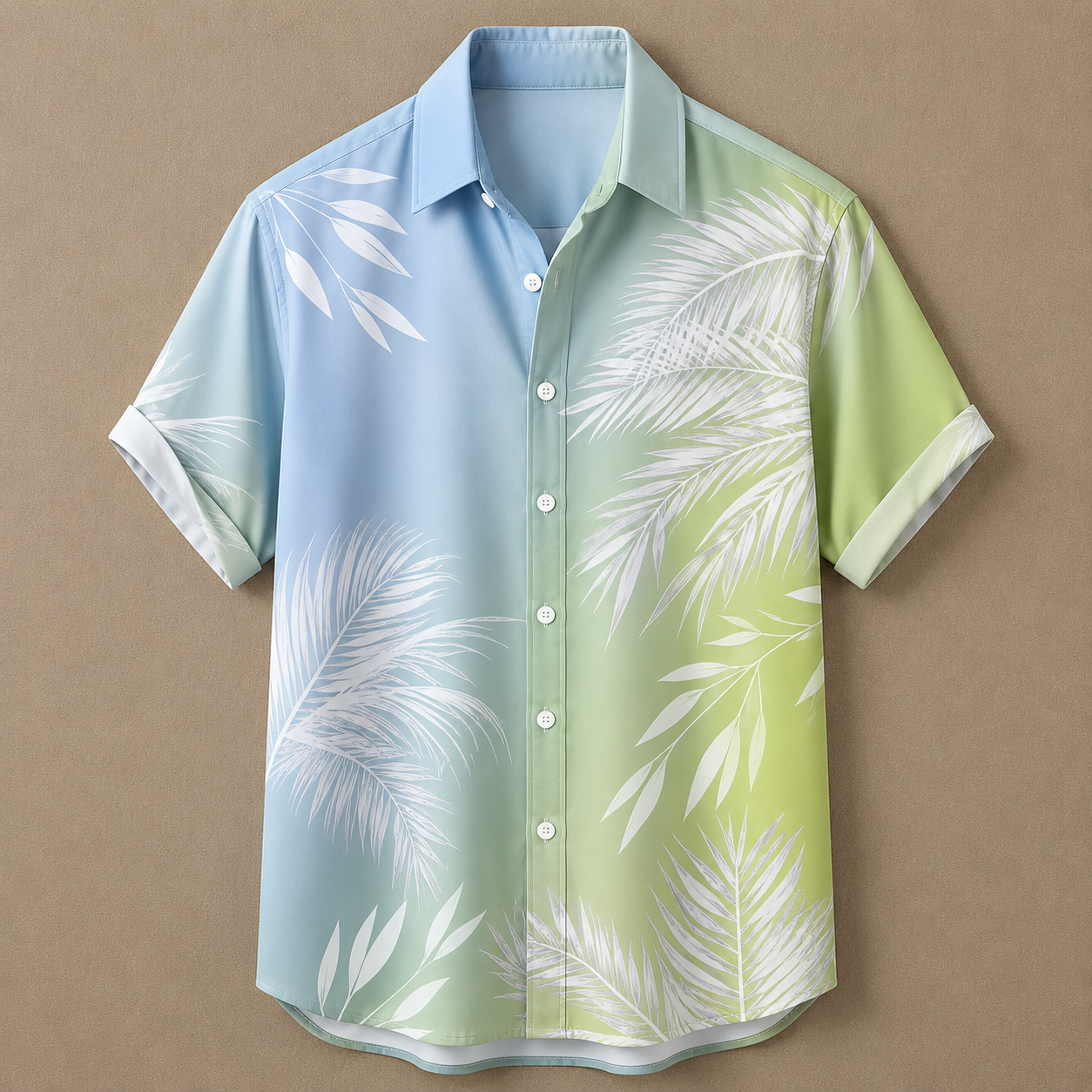 A short-sleeve button-up shirt with a tropical palm leaf print, featuring a gradient color scheme from light blue on the left to light green on the right, displayed against a solid brown background.