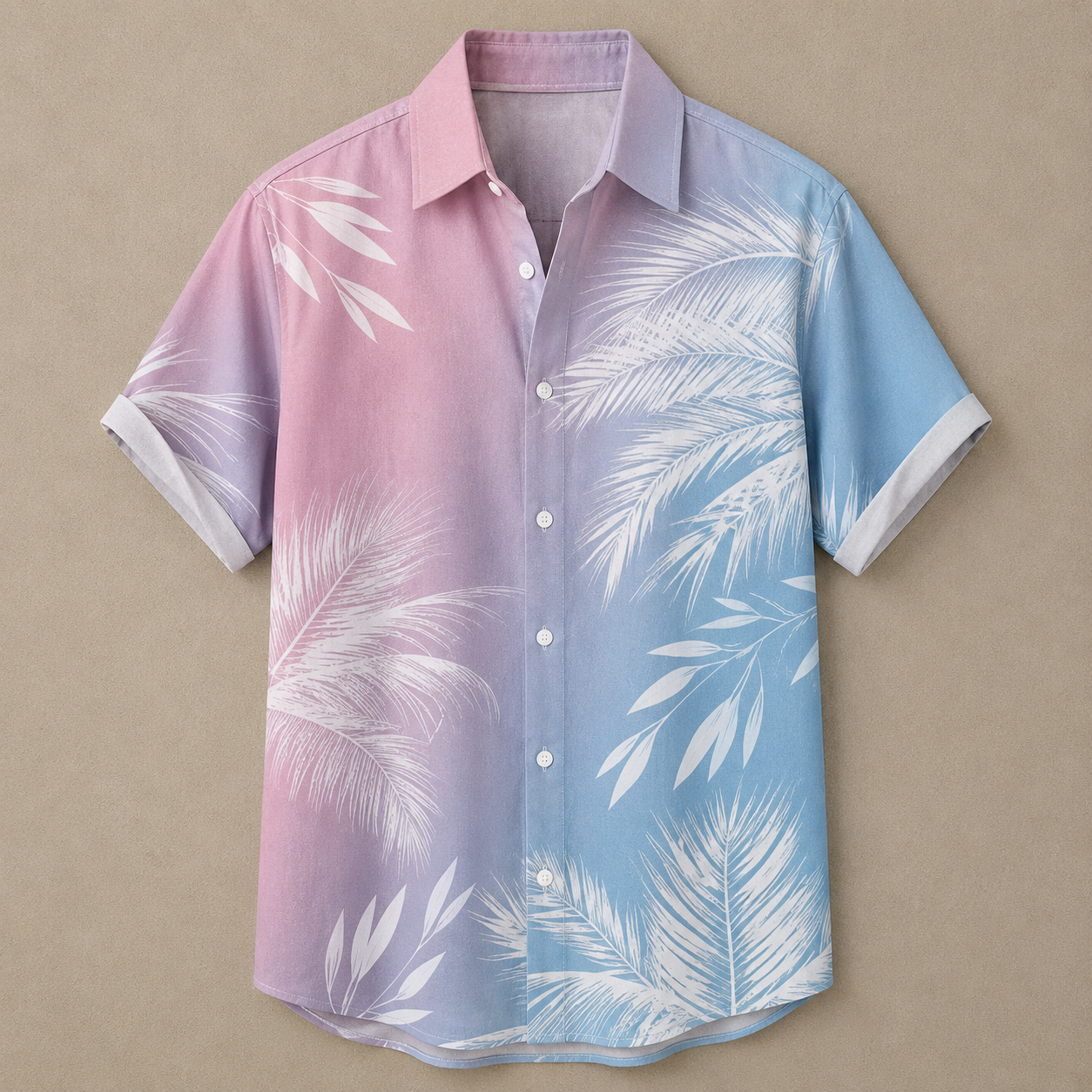 A short-sleeve button-up camp shirt with a pink-to-blue gradient and white palm leaf print, laid flat on a beige background.