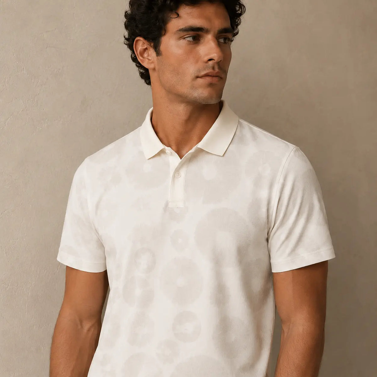 Man wearing a white polo shirt against a beige background