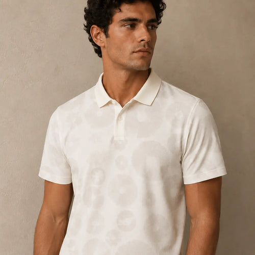 Man wearing a white polo shirt against a beige background