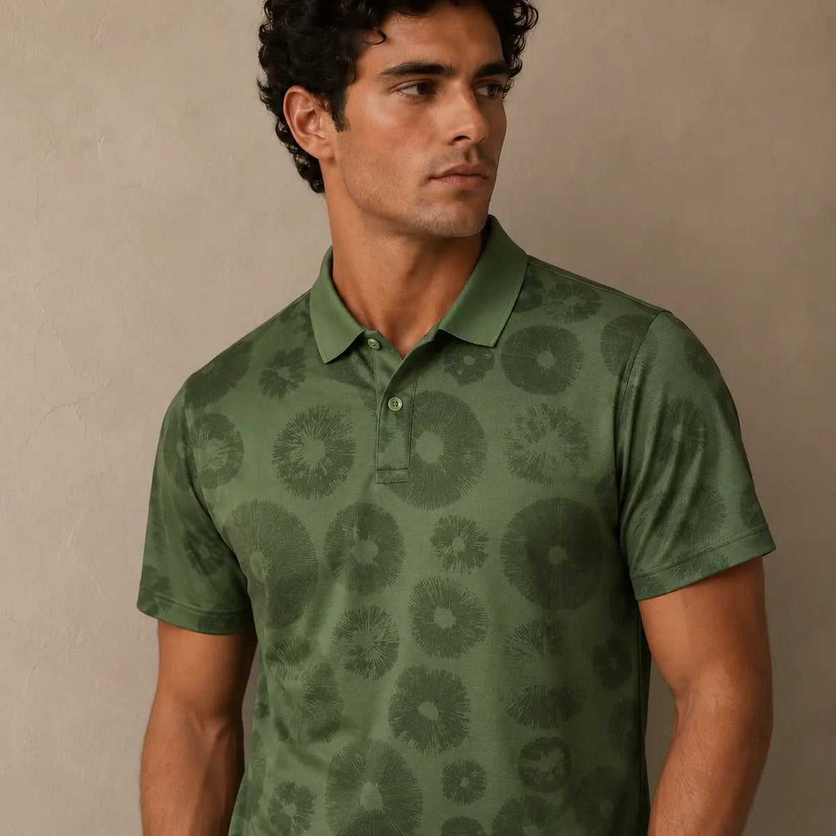 Man wearing a green patterned polo shirt against a beige background