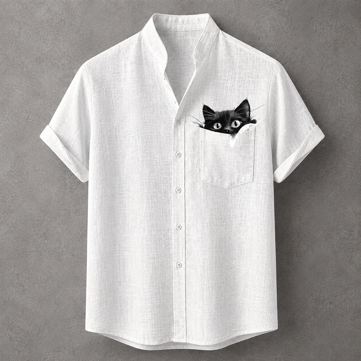 A white short-sleeve button-up shirt with a black cat peeking out of the chest pocket, displayed against a textured gray background.